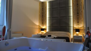 A hotel room with a large bathtub, a bed with two bedside tables, and a large mirror. - Navona Nice Room (Rome)