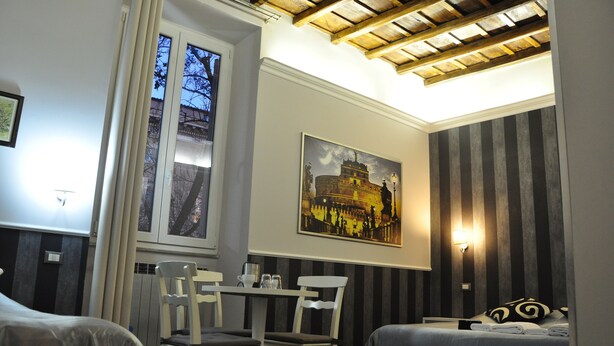 A hotel room with a bed, a dining table with chairs, a window with curtains, a painting on the wall, and a striped wall panel. - Navona Nice Room (Rome)
