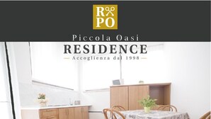 A modern kitchen with wooden cabinets, a dining table with chairs, and a small potted plant. - Piccola Oasi (Vigonza)