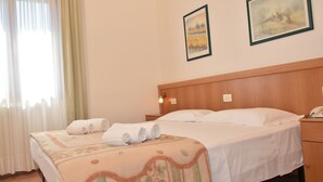 A hotel room with a bed, a nightstand, and a window with curtains. - Piccola Oasi (Vigonza)