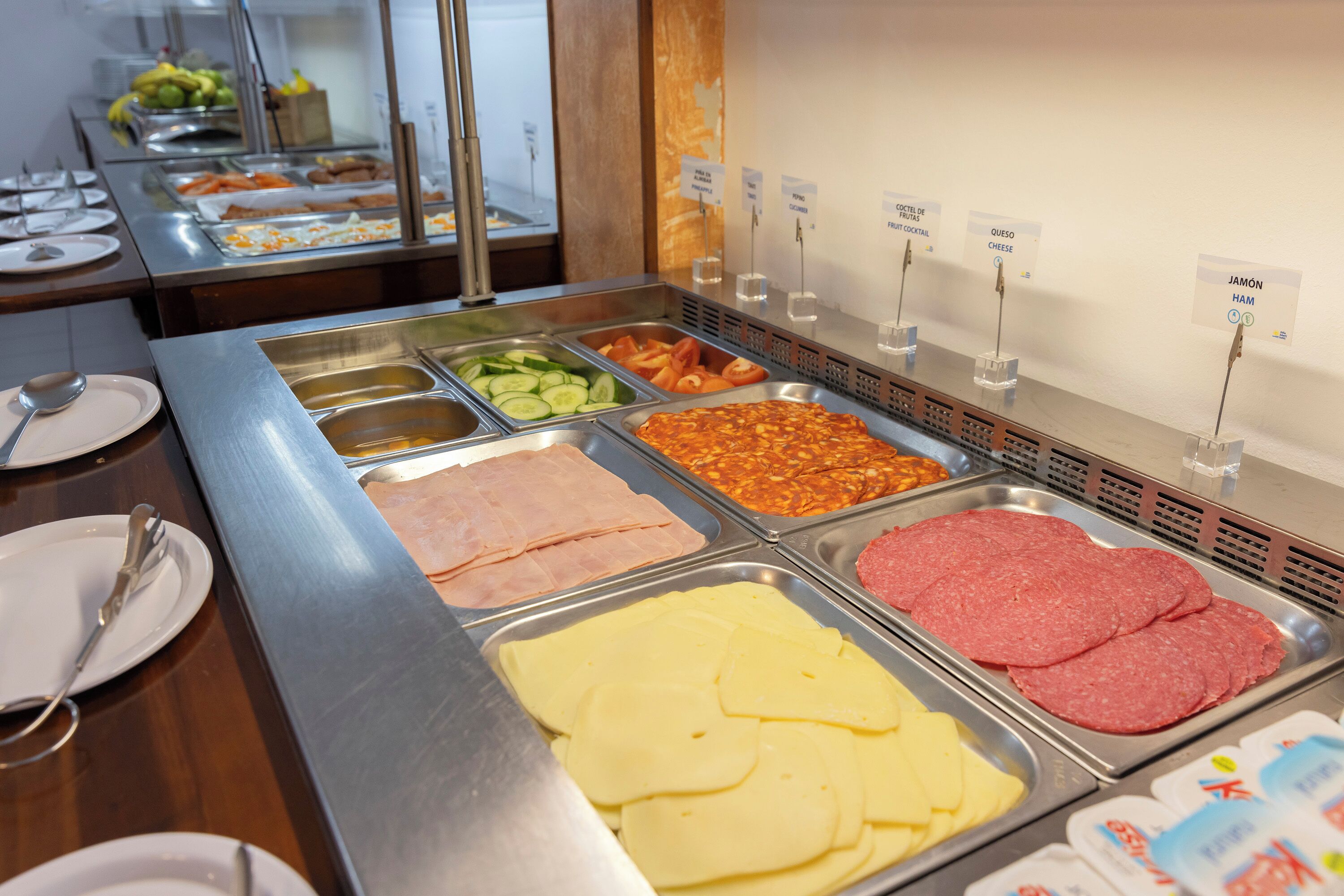 A buffet with various food options including meats, cheeses, and vegetables.