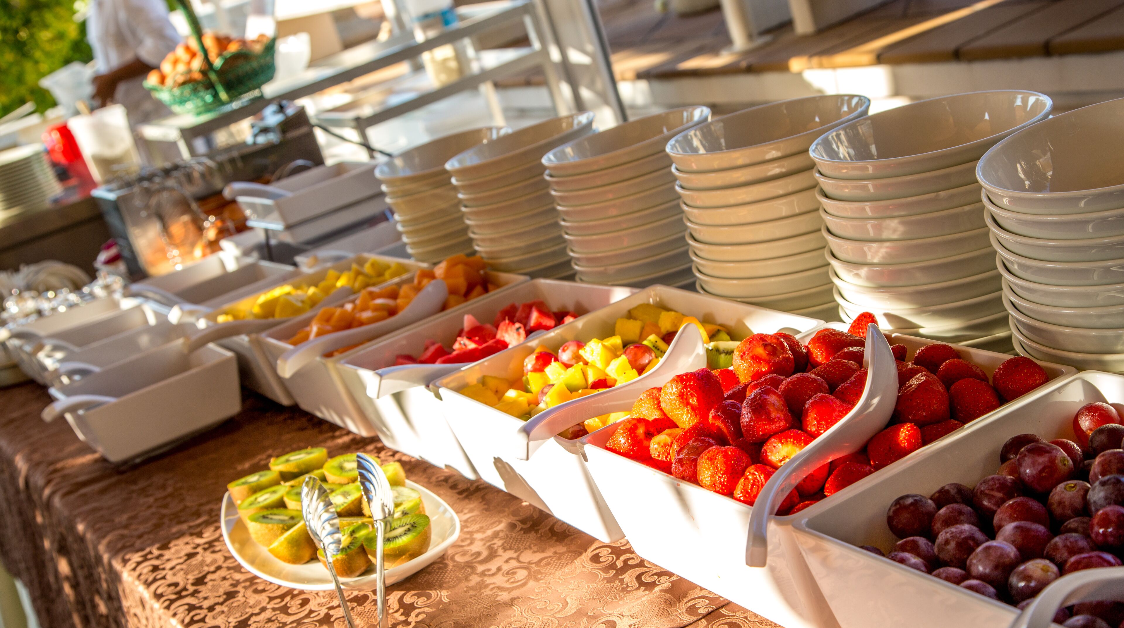 A buffet with various fruits and bowls of food.