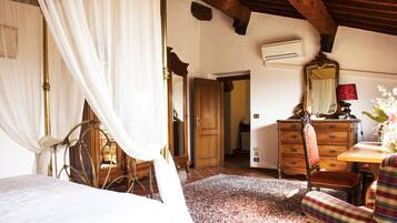 Un dormitorio con cama de dosel, muebles de madera y alfombra estampada.