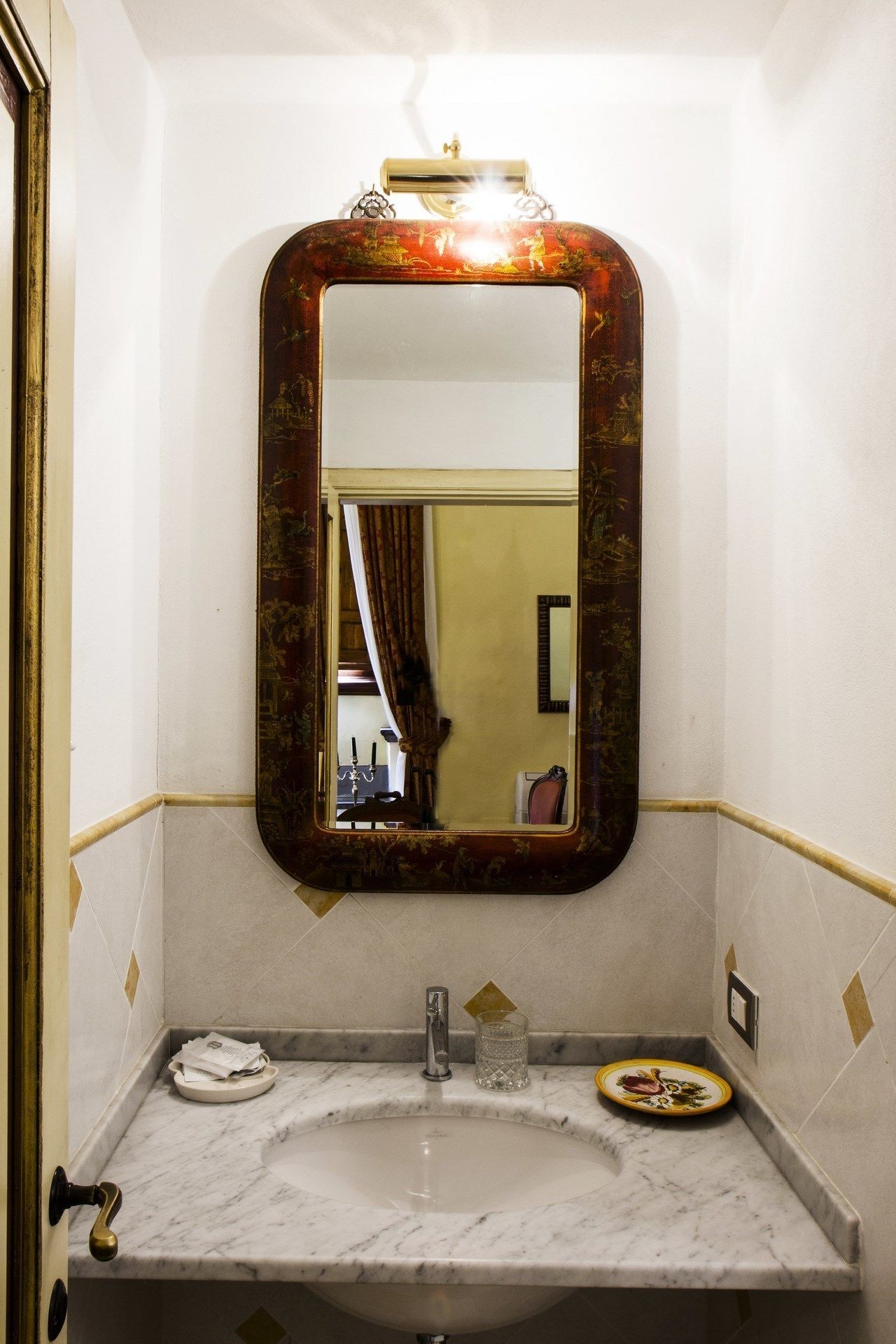 A bathroom with a marble sink, a large ornate mirror, and a towel rack.
