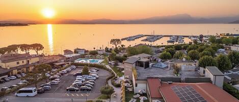 A marina with boats, a parking lot, and buildings with solar panels.