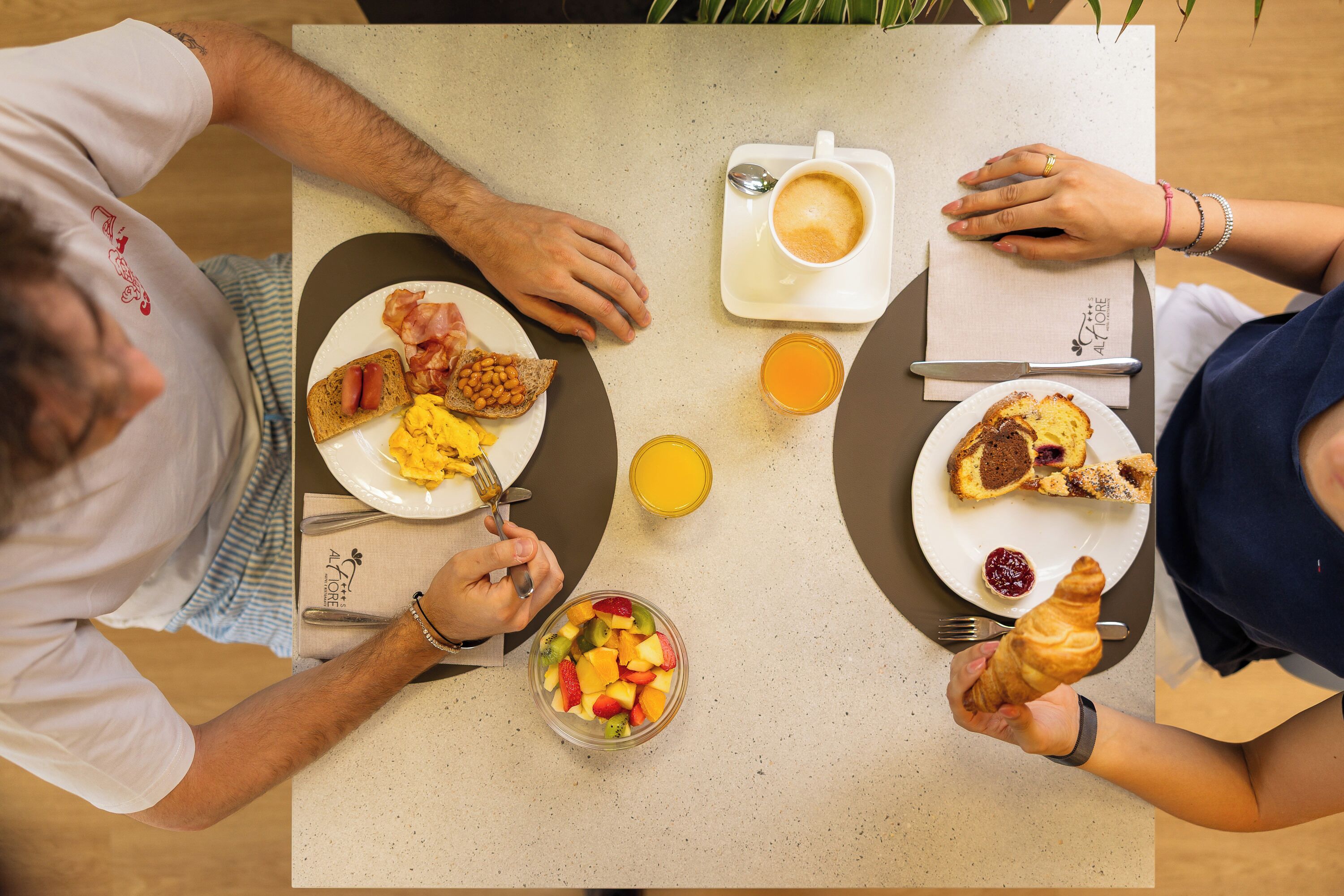 Una mesa con alimentos para el desayuno, como tostadas, huevos y un bol de fruta.