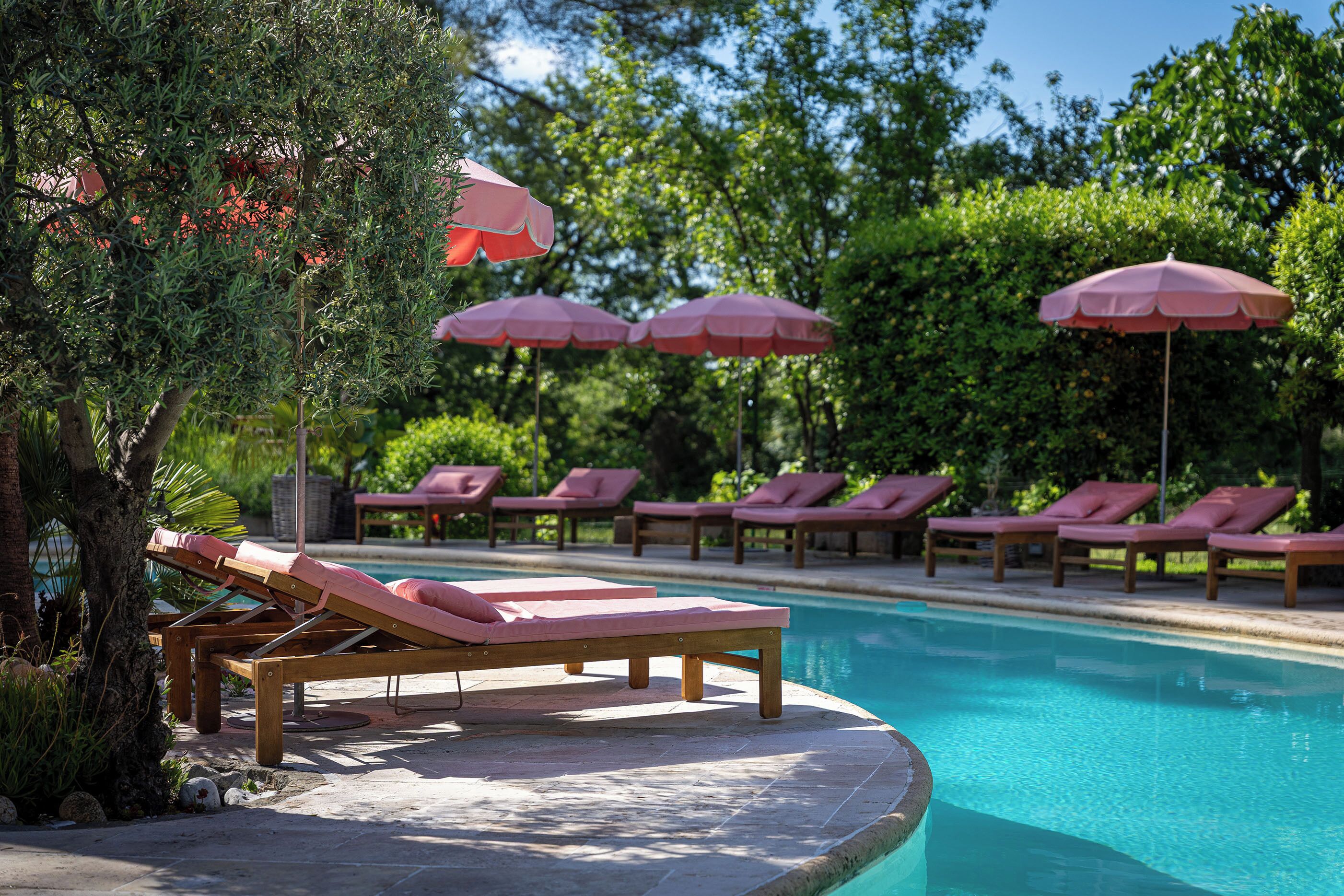 Ein Poolbereich mit Liegestühlen und Sonnenschirmen.
