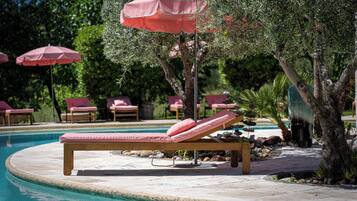 A poolside area with lounge chairs and umbrellas.