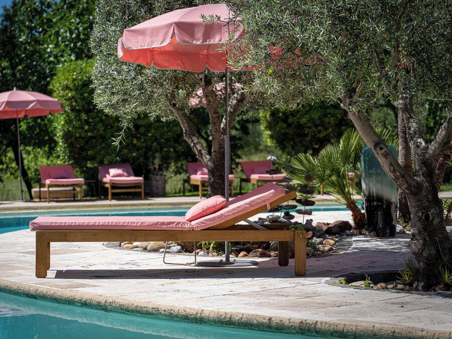 A poolside area with lounge chairs and umbrellas.