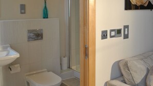 A bathroom with a toilet, sink, and shower. There is a towel rack and a painting on the wall. - Dreamhouse Manchester Deansgate (Manchester)