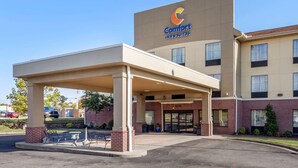 A Comfort Inn & Suites building with a covered entrance, brick facade, and a clear sky. - Comfort Inn & Suites Atoka-Millington (Atoka)