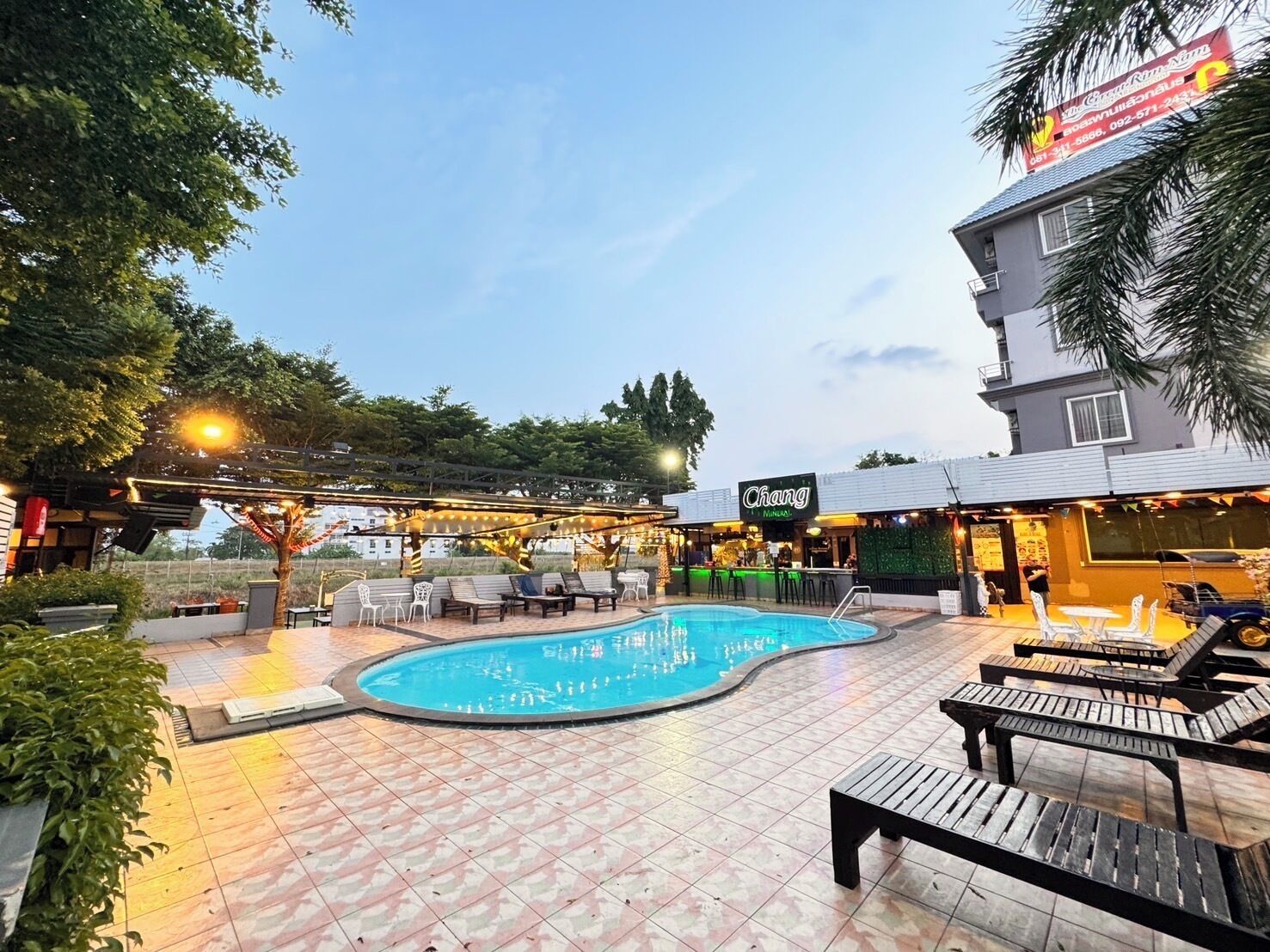 A pool area with lounge chairs and a bar.