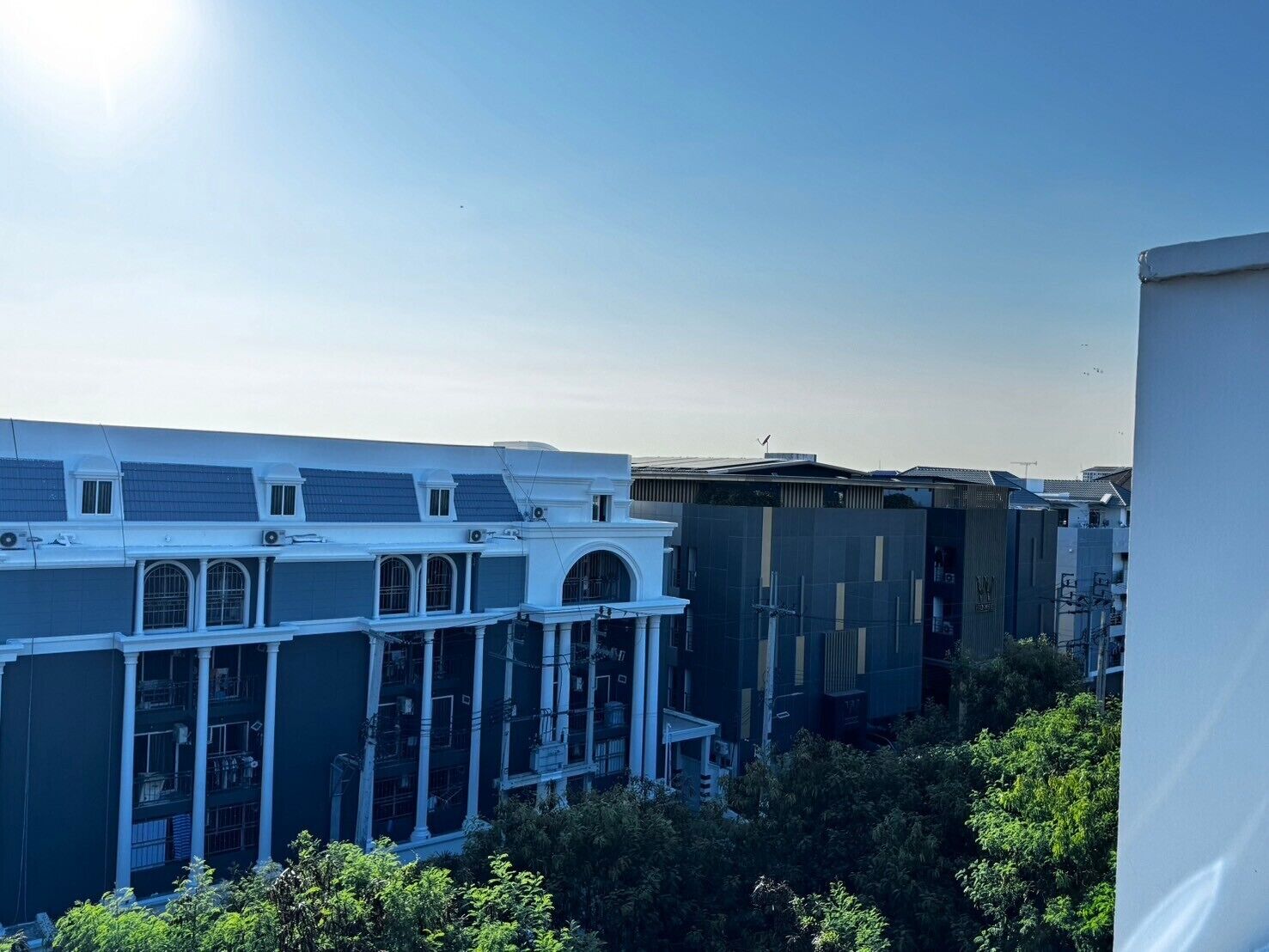 Een meerlaags gebouw met een plat dak, grote ramen en een balkon.