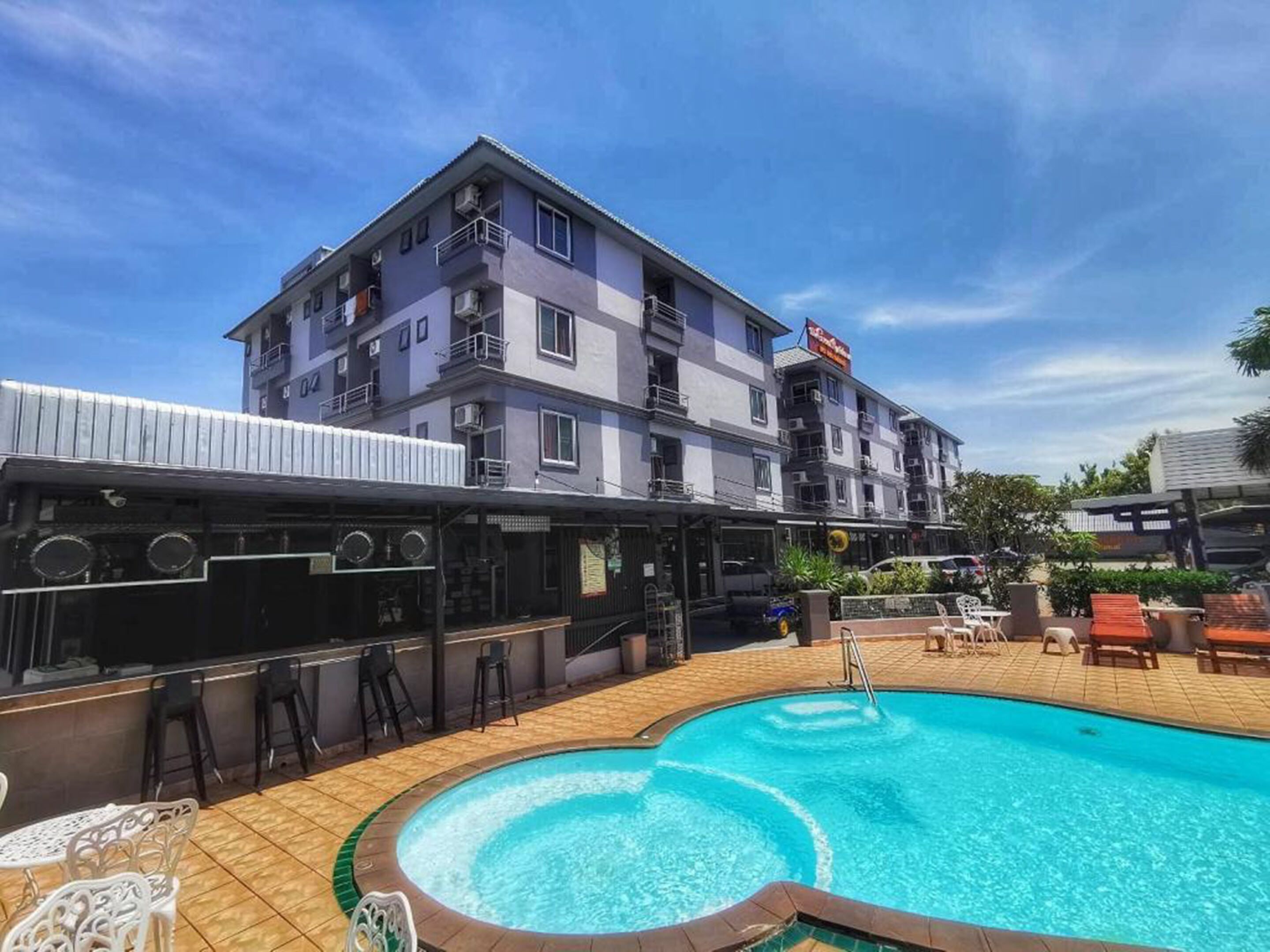 Un hôtel doté d’une piscine, d’un espace extérieur aménagé et d’un bar.
