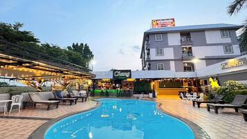 Área da piscina com espreguiçadeiras, bar e restaurante chamado 'Chang'.