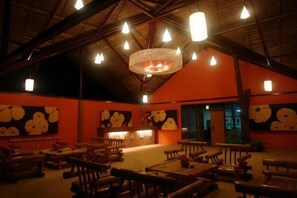 Un restaurante con muebles de madera y un techo alto.