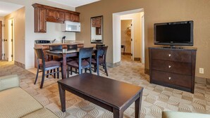 A living room with a dining area, a TV, and a kitchen.