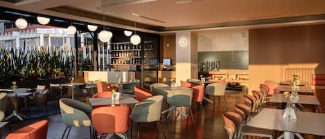 A modern restaurant interior with multiple seating areas, a bar, and a view of the cityscape.