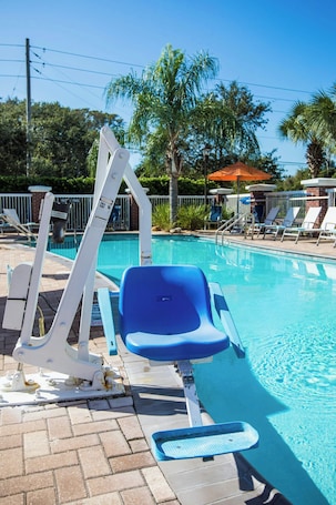 Una piscina al aire libre, sombrillas, sillones reclinables de piscina