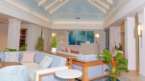 A spacious living area with a high ceiling, built-in seating, and a large window with a view.
