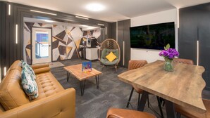 Un salon moderne comprenant un canapé, des fauteuils, une table basse et une table à manger.