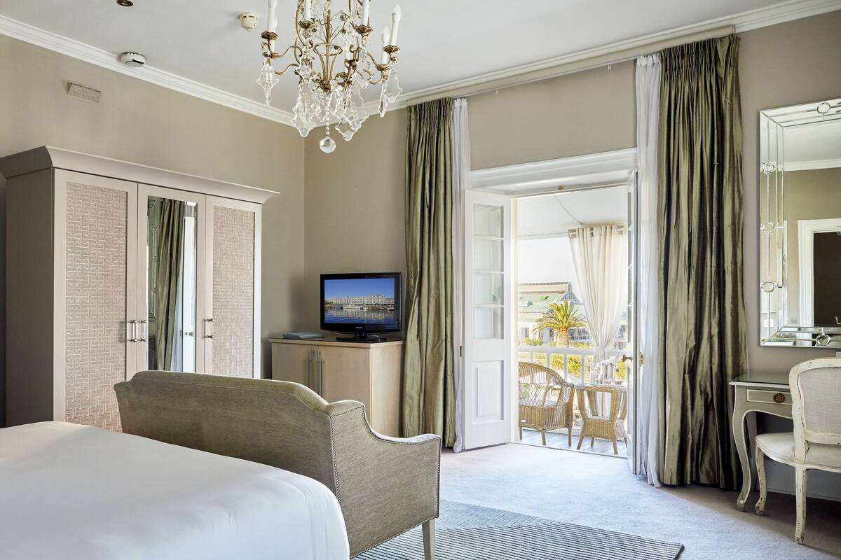 Ein Hotelzimmer mit einem Bett, einem Fernseher, einem Schreibtisch und Blick ins Freie.