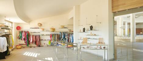 A spacious boutique with neatly organized clothing racks, a central display table, and a modern interior design.