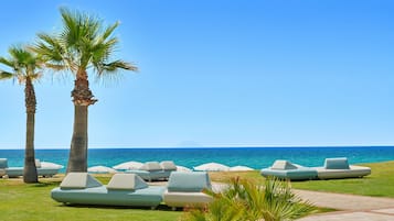 A beachside lounge area with palm trees and lounge chairs.