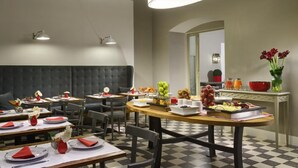 A restaurant with tables set for dining, a bar area with drinks, and a buffet with various food items. - Hotel Rosso 23 (Florence)