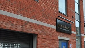 A brick building with a sign for 'Dreamhouse Luxury Apartments & Suites'.