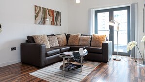 A modern living room with a sectional sofa, a coffee table, and a floor lamp.