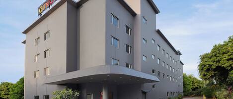 A modern hotel with a flat facade, multiple windows, and a prominent entrance with a covered area.