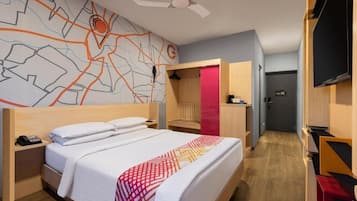 Habitación de hotel con cama, escritorio, silla, armario y pared con diseño de mapa.