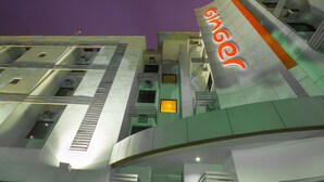 Un edificio moderno con un letrero naranja llamativo que dice "ginger".