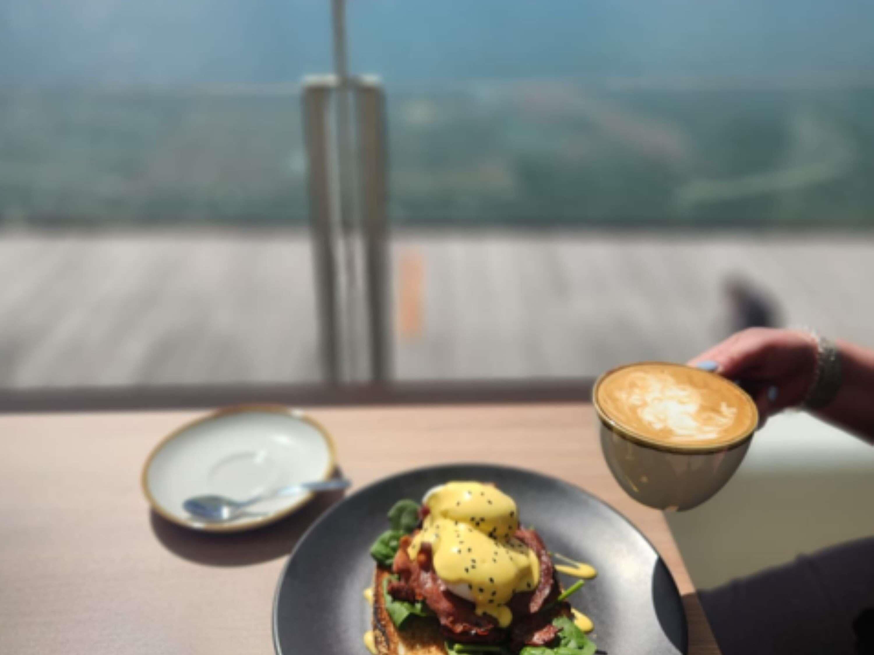 Ein Tisch mit einem Teller Essen und einer Kaffeetasse.