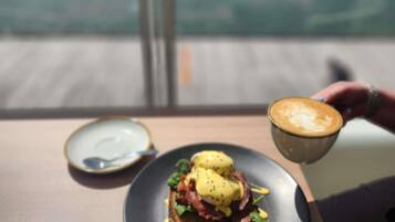 Ein Tisch mit einem Teller Essen und einer Kaffeetasse.