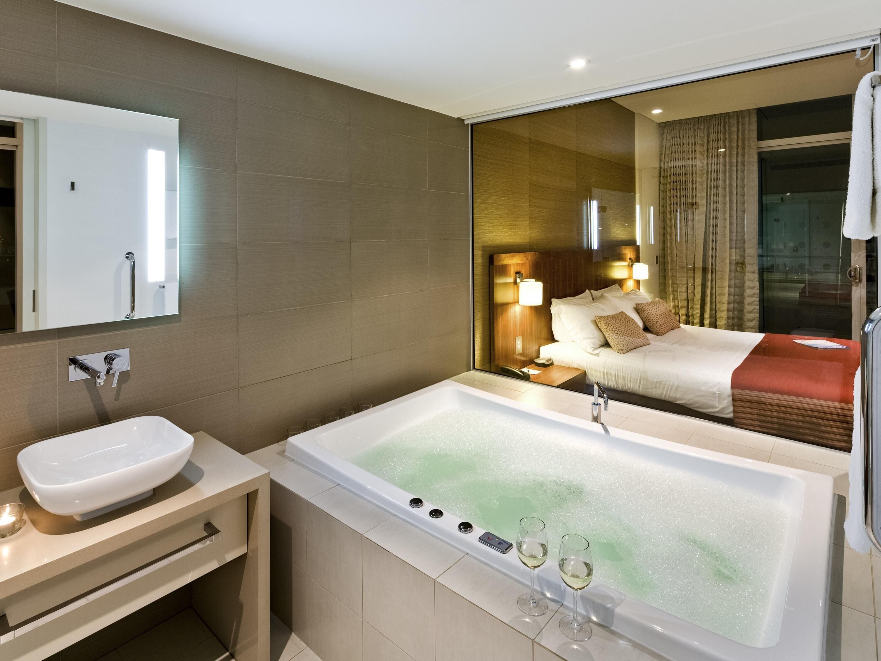 Un baño moderno con bañera, lavabo y espejo.