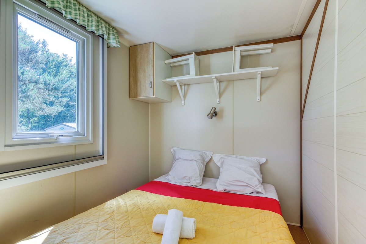 Una camera da letto piccola con un letto, una finestra e una mensola a parete.