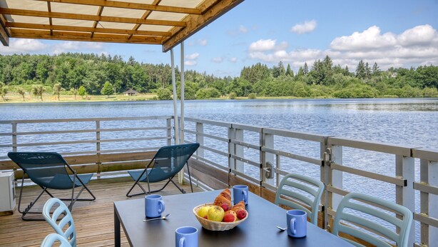 A covered outdoor seating area with a table, chairs, and a fruit bowl. - VVF Corrèze Pays d'Eygurande (Eygurande)