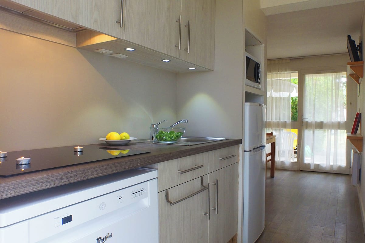 A modern kitchen with a built-in dishwasher, a sink, and a refrigerator.