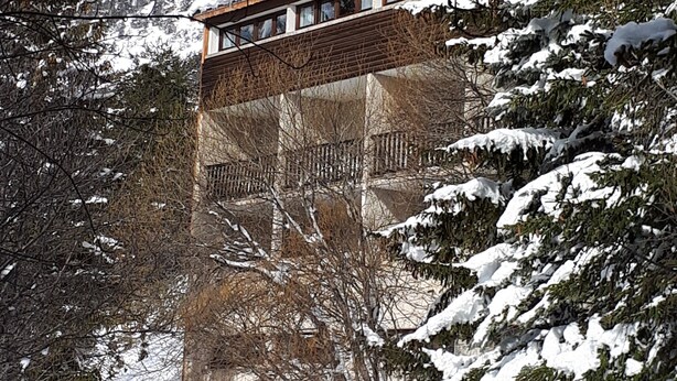 A building with a wooden facade and a balcony overlooking a snowy landscape with mountains in the background. - VVF Queyras, Ceillac-en-Queyras (Ceillac)