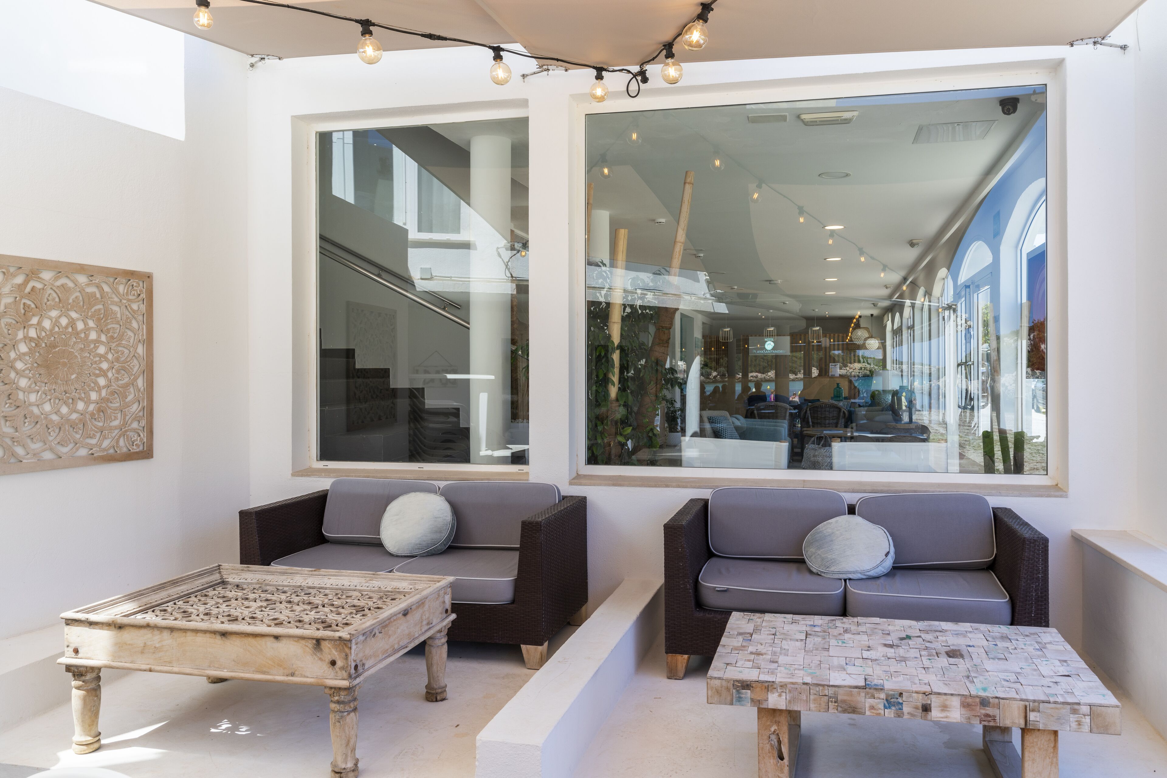 A modern interior with two sofas, a coffee table, and a decorative wall piece.