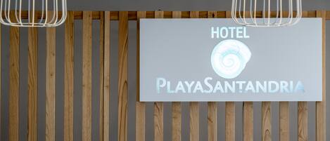 A hotel sign with the name 'PlayasSantandria' and a seashell logo.