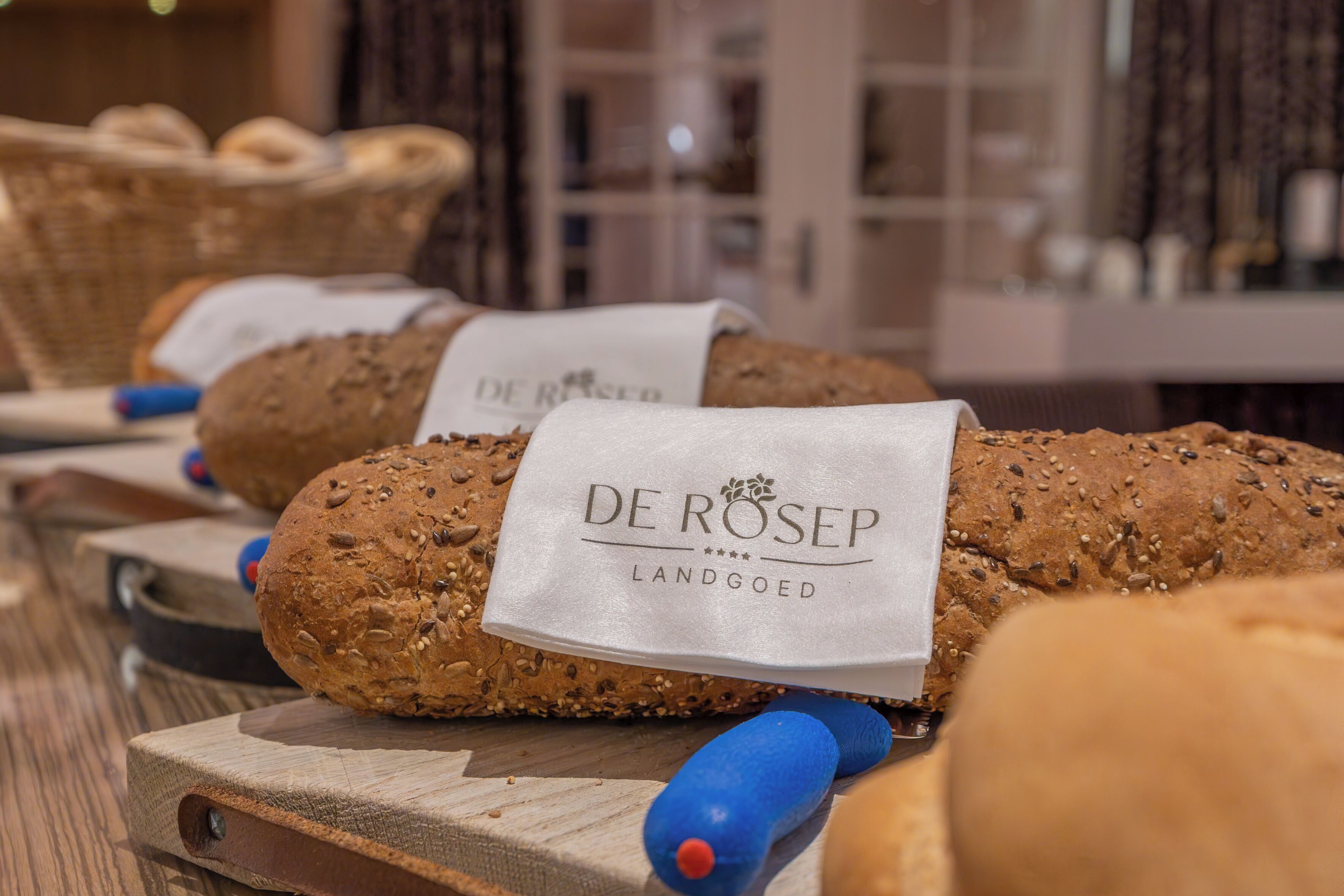 Presentación de pan De Rosep con etiquetas, sobre tablas de madera en un panadería.