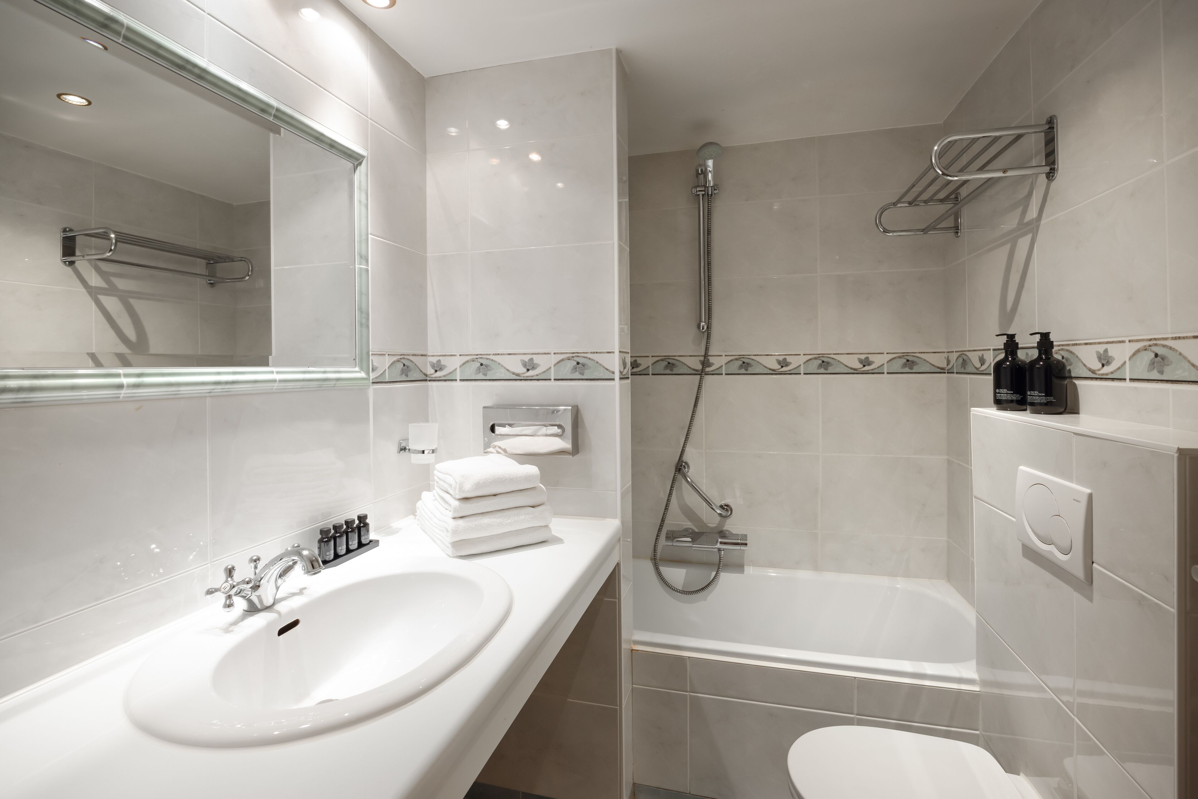 A modern bathroom with a sink, mirror, and shower.