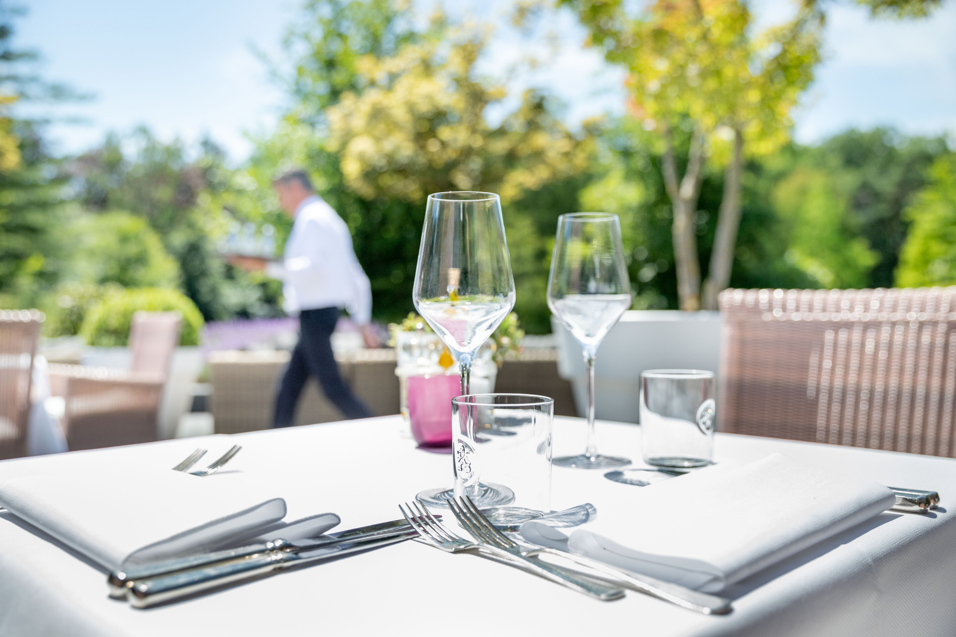 A table set outdoors with a clear view of a person walking in the background.
