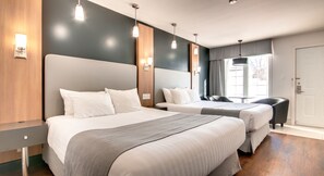 Habitación de hotel con dos camas, cabecero de madera, mesita de noche y ventana con cortinas.