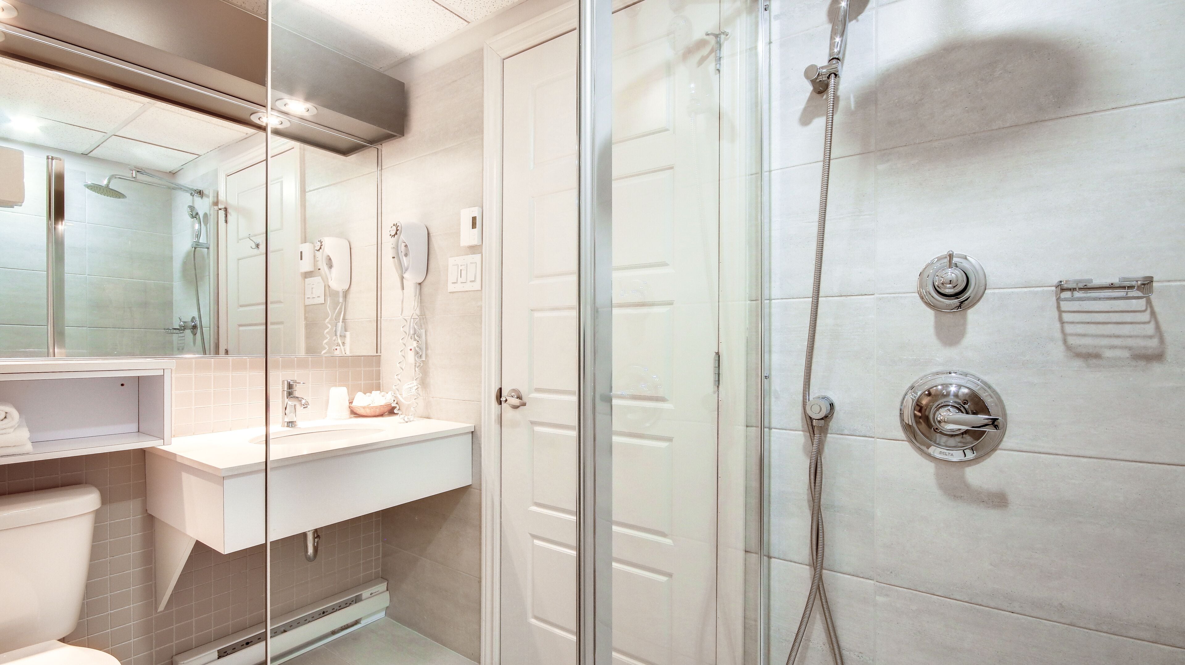 Une salle de bain moderne avec une douche à parois de verre, un meuble-lavabo avec un miroir et des toilettes.