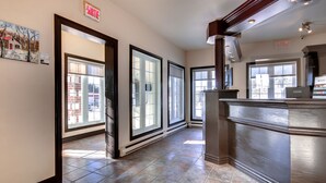 A hallway with large windows, a reception desk, and a sign indicating a sale.