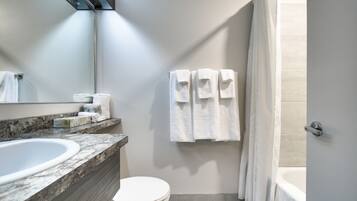 Un baño moderno con lavamanos de mármol, inodoro y bañera.